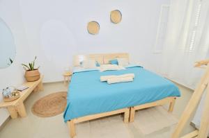a bedroom with a blue bed with two pillows at Casa Sodadi in Praia