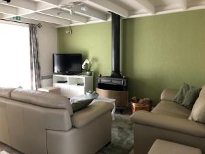 Sala de estar con 2 sofás y TV en Vissershuisjes ‘Duinendaele 65’, en De Panne