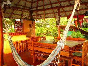a hammock in a restaurant with a table and chairs at Fidelito Ranch & Lodge in Tambor