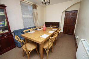 a dining room with a wooden table and chairs at Jo's House in Walsall