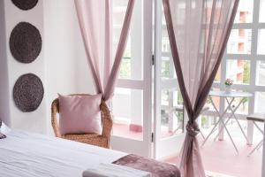 um quarto com uma cama, uma cadeira e uma janela em 4U Lisbon Suites & Guesthouse VII Airport em Lisboa