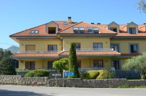 a large yellow house with a red roof at Apartamento Tere in Llanes