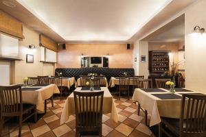 a restaurant with tables and chairs in a room at Conviva in Panevėžys