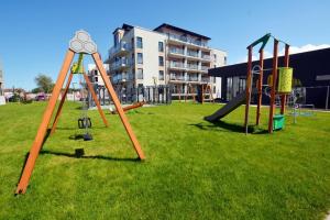 a park with a playground with a slide and swings at Apartament Victoria 5 Mórz in Sianozety