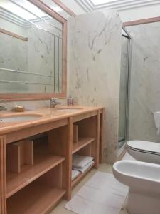 a bathroom with a sink and a toilet and a mirror at Atlantic Waves Accommodation in Carcavelos