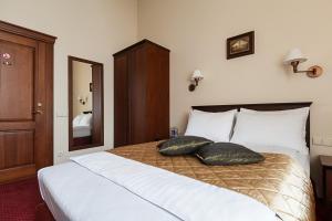 a bedroom with a large bed with two pillows on it at Conviva in Panevėžys