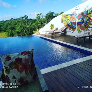 un complejo con una piscina con una almohada en la terraza en Villa Nobre Diniglei, en Trancoso