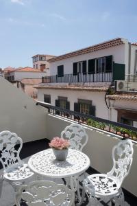 a balcony with a table and chairs on a balcony at Antonella Home Funchal in Funchal