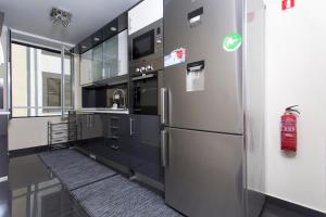 a kitchen with a stainless steel refrigerator and a sink at Antonella Home Funchal in Funchal