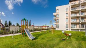 a playground in front of a large building at Apartament Victoria 5 Mórz in Sianozety