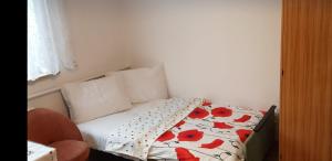 a small bedroom with a bed with red flowers on it at POKÓJ POMORSKA in Elblag