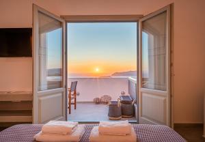 a room with a bed and a view of the ocean at Caldera Stories private suites in Megalokhori