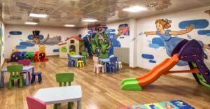 una sala giochi per bambini con un murale di Hotel Club Regina E Fassa a Mazzin