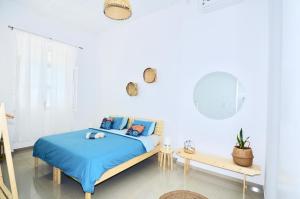 a white bedroom with a bed and a table at Casa Sodadi in Praia