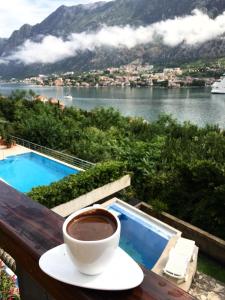 Una taza de café en una mesa junto a la piscina en Villa "M Family", en Kotor