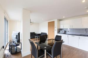 a kitchen and dining room with a table and chairs at Modern 2 Bed 2 Bath Apartment Hyde Park in London