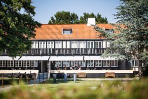 a building with a table and chairs in front of it at Molskroen in Ebeltoft +15 photos