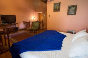 Un dormitorio con una cama con una manta azul. en Posada del Puruay, en Cajamarca