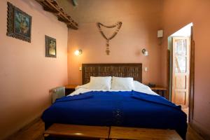 een slaapkamer met een blauw bed in een kamer bij Posada del Puruay in Cajamarca