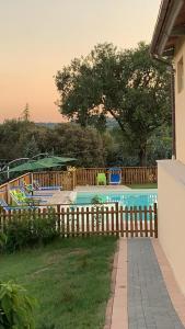 a swimming pool in a yard with a wooden fence at Agriturismo Villalta in Ponte Felcino