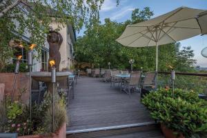 a wooden deck with tables and an umbrella at Hotel Schöne Aussicht in Frankfurt