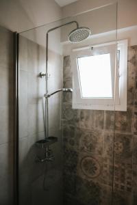a shower in a bathroom with a window at Jerry Apartments in Svoronata