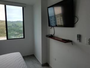 ein Schlafzimmer mit einem TV an der Wand und einem Fenster in der Unterkunft Edificio Nancabez III in Tonsupa