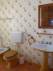 a bathroom with a toilet and a sink at CASA BERIMBAU in Vila Nova de Milfontes
