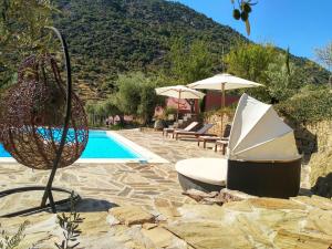 una piscina con una silla y una sombrilla junto a una piscina en Quinta Vale de Carvalho, en Pinhal do Douro