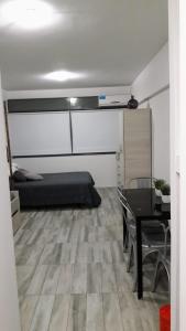 een slaapkamer met een bed en een tafel en een eetkamer bij Apartamento Syrah -Céntrico- in Mendoza