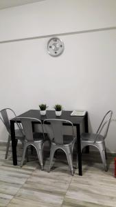 een zwarte eettafel met stoelen en een klok aan de muur bij Apartamento Syrah -Céntrico- in Mendoza