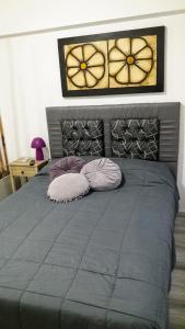 a bedroom with a gray bed with two pillows at Apartamento Syrah -Céntrico- in Mendoza