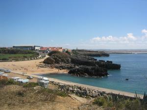 a beach with a bunch of rocks in the water at Casa São João in Peniche