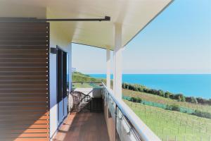 a balcony of a house with a view of the ocean at Chalets at Okurukuru in New Plymouth