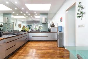 a large kitchen with white cabinets and a hard wood floor at Pura Villa in Sanur