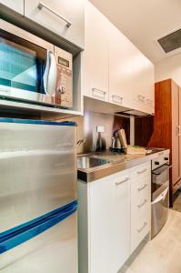 a kitchen with white cabinets and a stainless steel refrigerator at VR Auckland City in Auckland