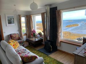 a living room with a view of the ocean at Berneray Otter Cottage in Berneray