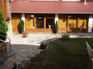 una casa con patio y un edificio con techo rojo en Mediterrán Vendégház, en Kecskemét