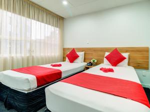 two beds in a room with red and white at Ascotia Off Queen in Auckland