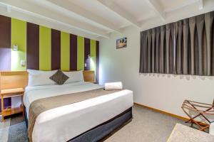 Un dormitorio con una cama grande y una ventana en The Lofts Apartments, en Queenstown
