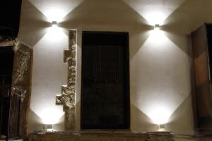 dos luces en el costado de una pared con un espejo en Dimore San Nicola en Favara