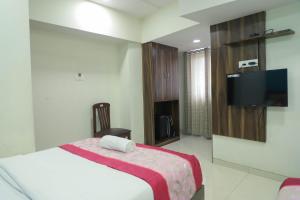 una camera da letto con un letto e una TV a schermo piatto di Hotel Plaza Executive - near BKC a Mumbai