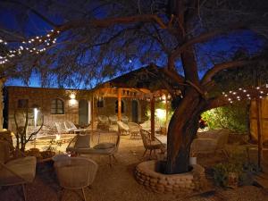 eine Terrasse mit einem Baum, Stühlen und Lichtern in der Unterkunft Hotel Jardin Atacama in San Pedro de Atacama