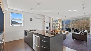 a kitchen and living room with a view of the mountains at Marina Apartment 406 in Queenstown
