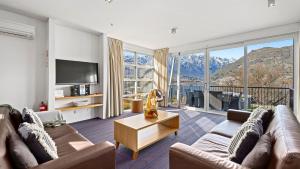 a living room with a couch and a tv at Marina Apartment 406 in Queenstown