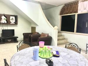 a living room with a table and a couch at Lestari Guesthouse in Padang