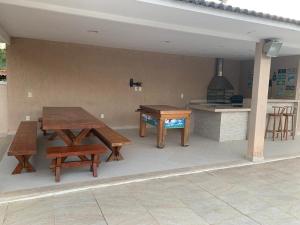 a patio with two picnic tables and a kitchen at Casa Búzios - Temporada in Búzios
