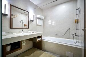Lailai Hotel في تايتشونغ: حمام مع حوض ومغسلة ودش
