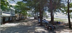 a motorcycle parked on the side of a street with trees at Tony Home and Restaurant in Karon Beach