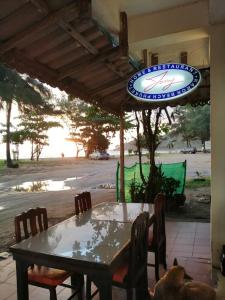 una mesa y sillas bajo una sombrilla en un patio en Tony Home and Restaurant en Karon Beach